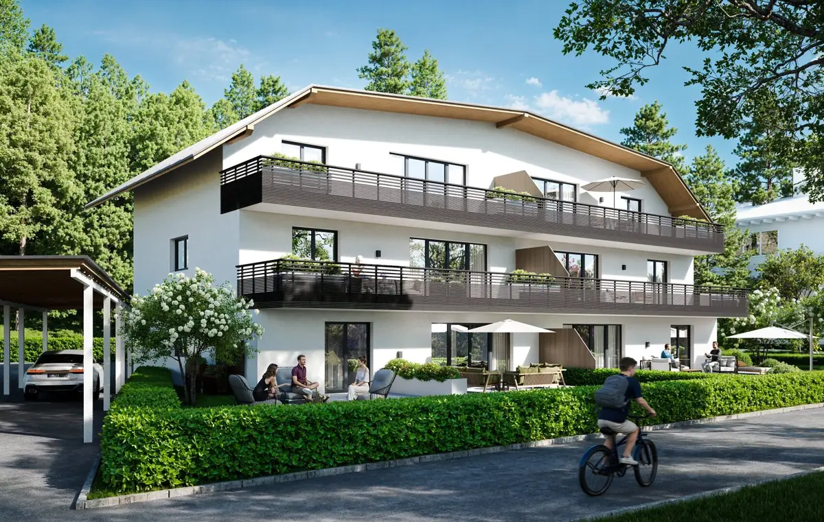 Gepflegtes Wohnhaus mit Balkonen und grüner Hecke, in dem Menschen zuhause sind